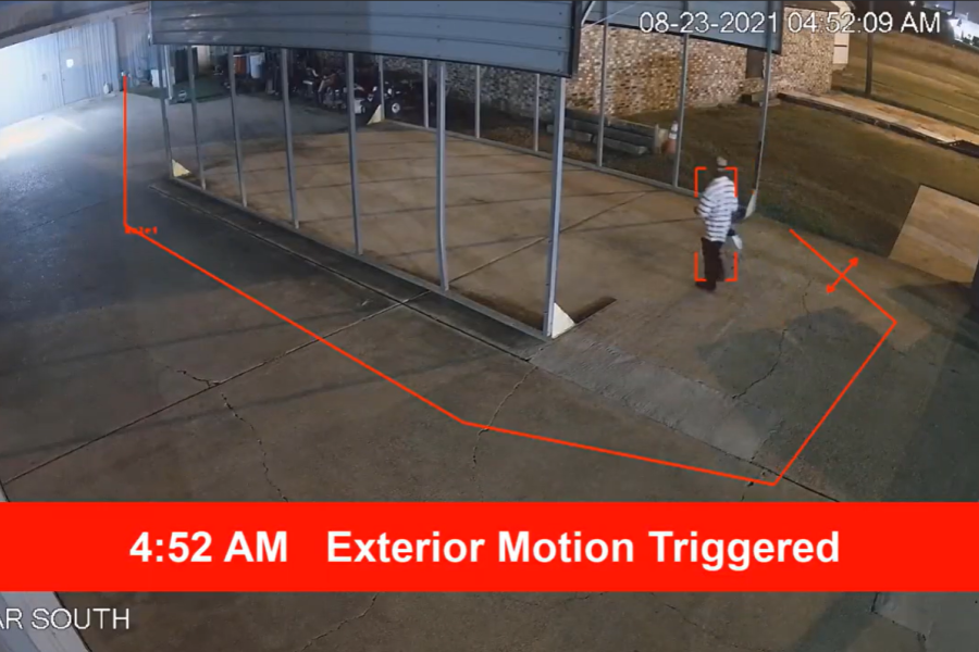 Security camera view of a person detected at 4:52 AM with a red motion alert banner and digital perimeter tracking.