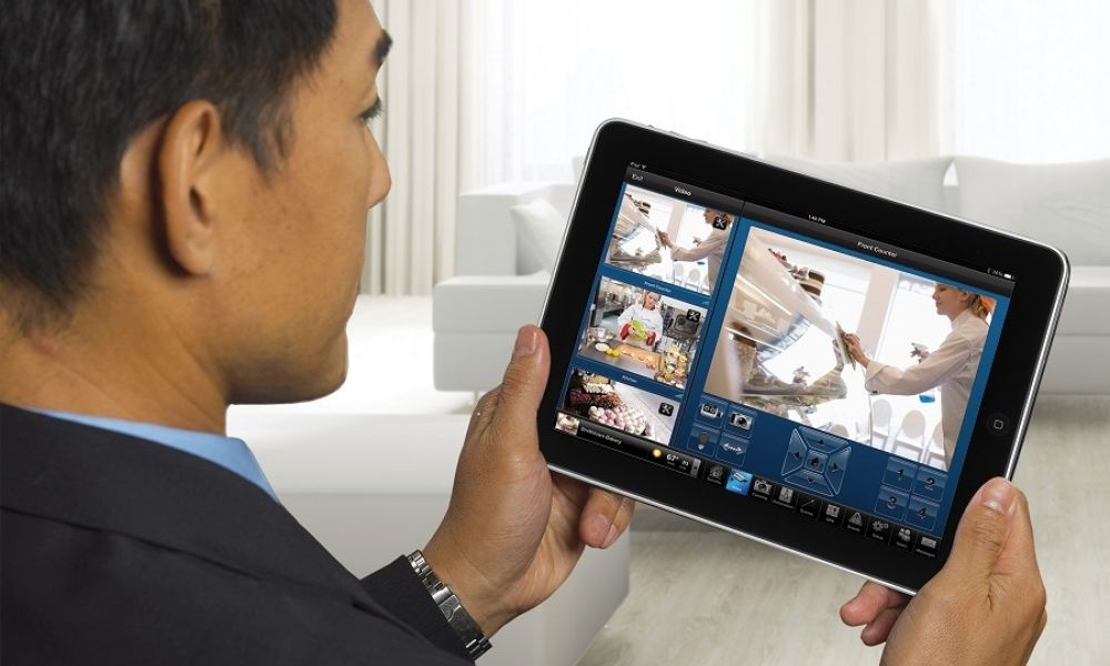 A person holding an iPad with images of people at work.