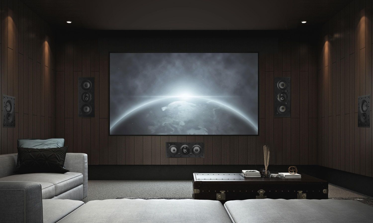 A luxury home theater featuring a large projection screen, built-in surround sound speakers, wood-paneled acoustic walls, and comfortable seating arranged around a coffee table. The room is designed for an immersive movie-watching experience with dim lighting and a cinematic atmosphere.