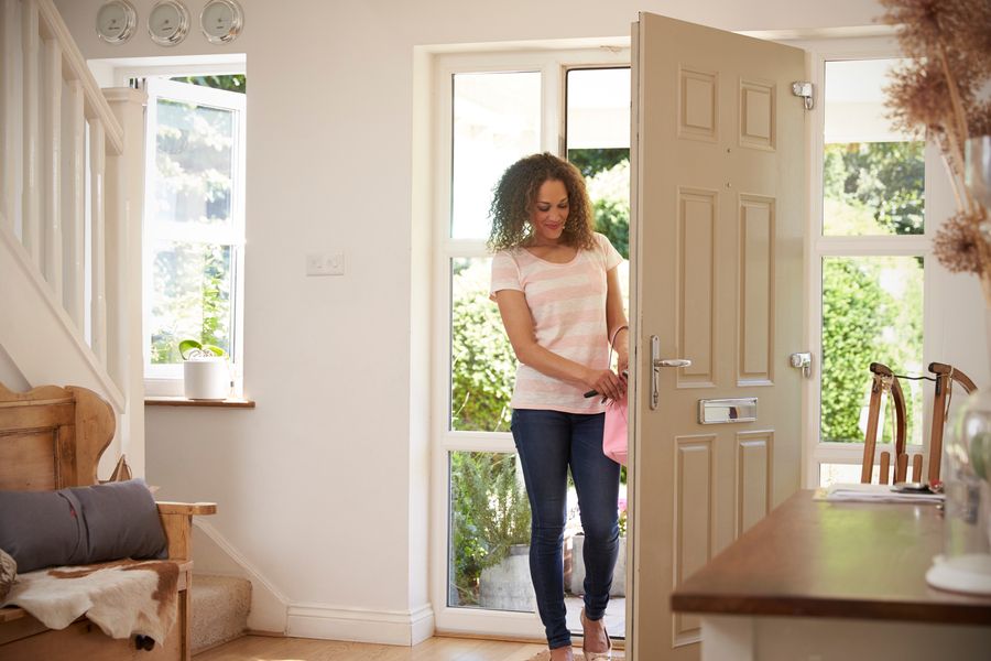 A woman walking through the front door into her home.