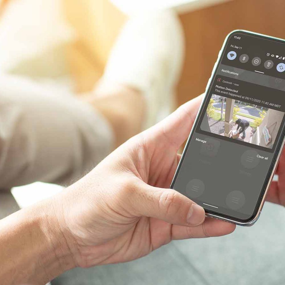 woman looking at her cell phone with surveillance on it