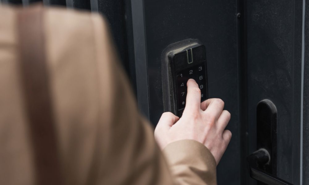 Person entering code on keypad to unlock a door.