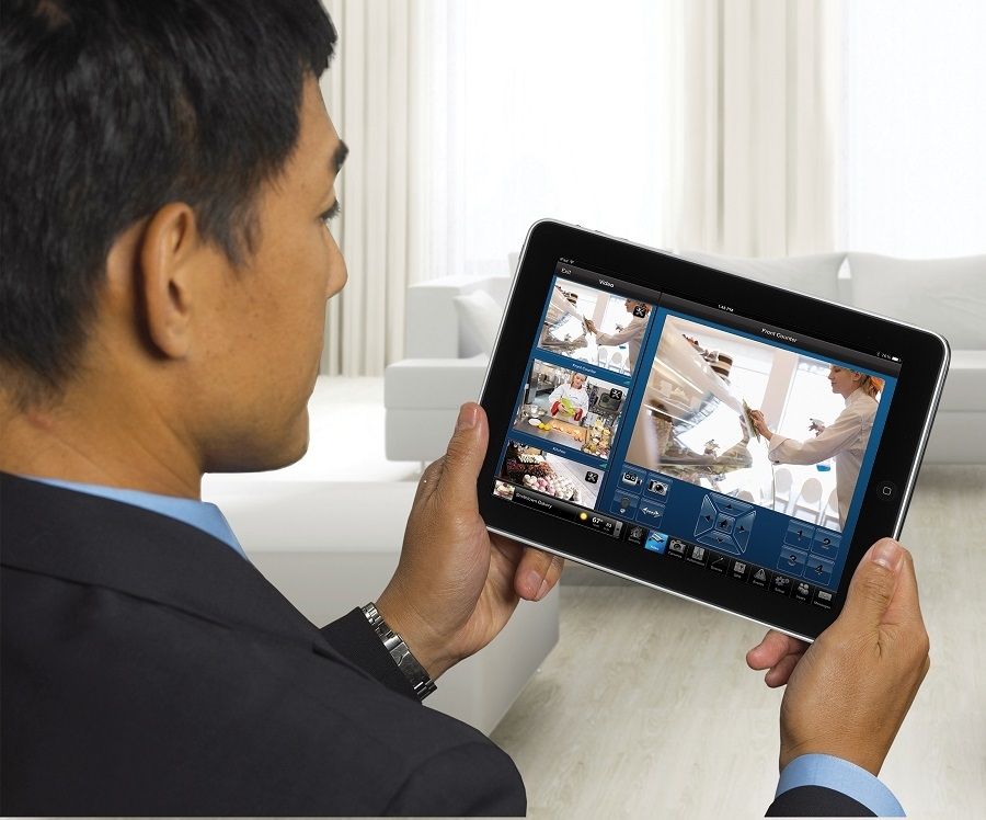 A person holding an iPad with images of people at work.