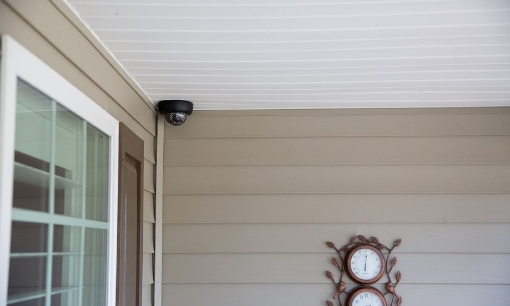 A Luma security camera on a porch roof by the front door.