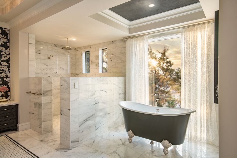 A bathroom illuminated by Ketra Lighting with a clawfoot bathtub and sunlight streaming through the window.